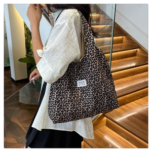 Lifestyle view of large leopard print nylon shoulder bag worn by model on stairs