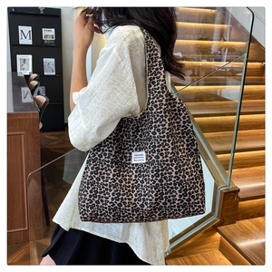 Lifestyle shot of large leopard print tote bag worn on shoulder by fashion model