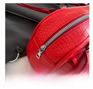Detail of red crocodile texture handbag with high-quality smooth silver metal zipper