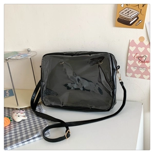 Detail of black crossbody ita bag with clear PVC front window for pins and dolls