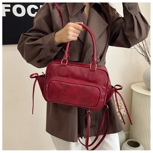 Detail of vintage wine red PU leather handbag with front zipper and top handle