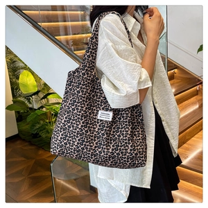 Close-up of stylish leopard print nylon tote bag with fashion label on modern stairs