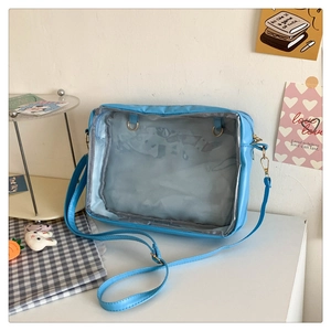 Detail view of light blue ita bag showing the clear PVC window and adjustable shoulder strap