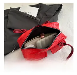 Internal capacity of the red crocodile pattern handbag showing room for phone and makeup