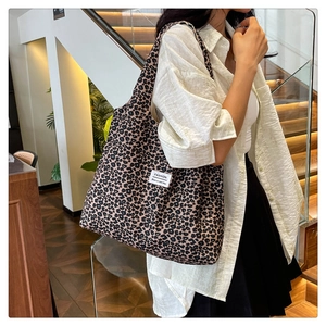 Detailed close-up of leopard print tote bag with a white fashion label on textured canvas