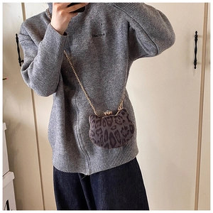 Detailed close-up of leopard print cat-shaped crossbody bag with gold chain strap