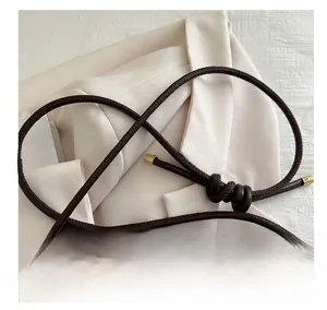 Détail du sac seau en laine avec bandoulière en corde, nœud et embouts dorés