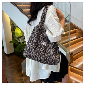 Close-up of leopard print tote bag side detail featuring white fashion fabric label