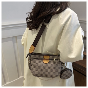 Detail view of a 3-in-1 monogram shoulder bag with wide strap and gold chain accessories