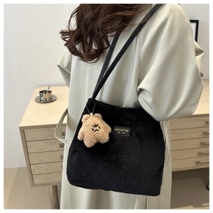Detail view of black faux fur shoulder bag with leather strap and star charm accessory