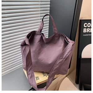 Dettaglio della capiente borsa tote in nylon viola su uno sfondo interno strutturato