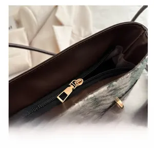 Vue détaillée de la fermeture éclair dorée sur le sac seau en laine texturée