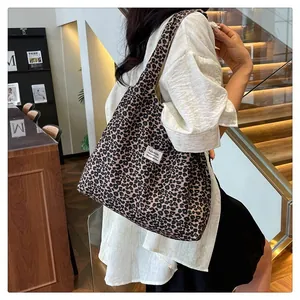 Detail showing the vintage leopard print tote bag with a white woven fashion label