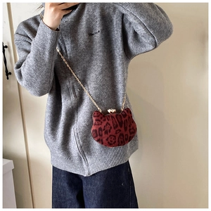 Detail of red leopard print cat-ear mini bag with gold chain and metal frame