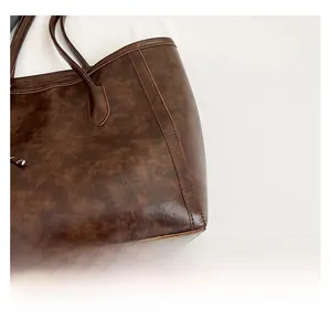 Close-up of deep brown tote bag showing vintage texture and reinforced stitching details