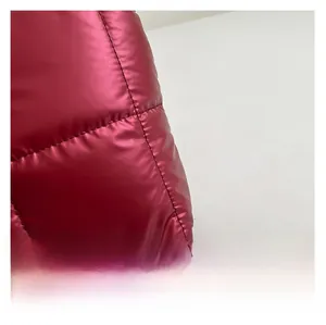 Gros plan détaillé du tissu matelassé rouge foncé avec finition métallique et texture