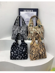 Detailansicht vier bedruckter Canvas-Tragetaschen mit Zebra-, Tiger- und Totenkopfmustern