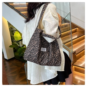 Detailed view of the leopard print fabric texture and white fashion label on a tote bag