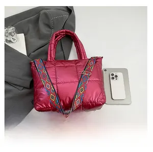 Détail du sac à main matelassé bordeaux avec fini métallisé et large bandoulière