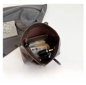 Interior view of large brown faux leather tote bag showing spacious storage for tablet and makeup
