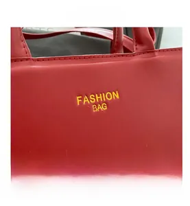 Close-up of red leather handbag with yellow Fashion Bag text and detailed stitching