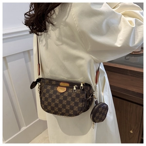 Detailed view of the brown checkered multi-pocket crossbody bag with golden chain