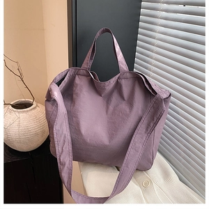 Grande borsa tote in tela viola con ampia tracolla in un ambiente dal design minimalista