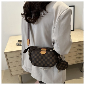 Detail of a retro 3-in-1 crossbody bag with brown check pattern and round coin pouch charm