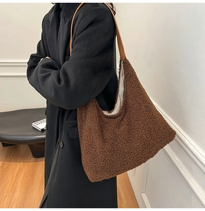 Detailed side view of the large dark brown plush tote bag with yellow leather shoulder strap