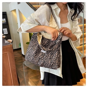 Detailed close-up of a large leopard print tote bag with a white woven label and soft fabric