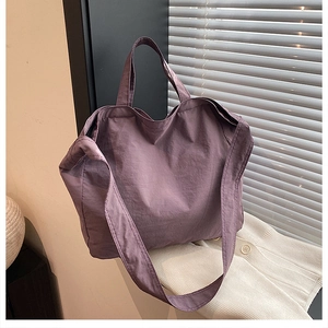Dettaglio ravvicinato della borsa tote in nylon viola scuro su tessuto a maglia e interni