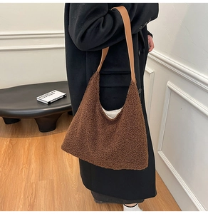Detail view of model wearing a large brown plush tote bag for winter casual fashion