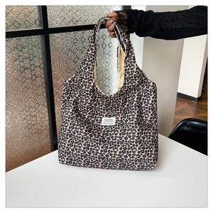 Detail shot of leopard print nylon tote bag with fashion label and beige inner lining