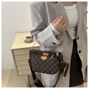 Detail view of a 3-in-1 crossbody bag with dark brown checkerboard pattern and gold chain