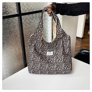 Detailed close-up of leopard print canvas tote bag featuring fashion label and large capacity