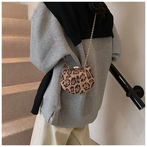 Detail showing leopard print texture and cat-shaped metal lock on small chain bag