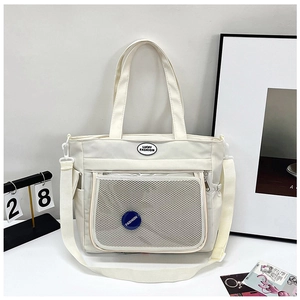 Dettaglio della borsa tote in nylon bianco con tasca a rete trasparente e badge fashion