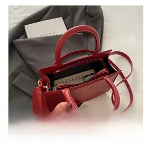Detail view of red leather handbag interior capacity showing phone and wallet storage
