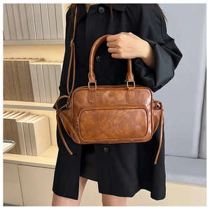 Brown vintage faux leather backpack shown with model in a minimalist library setting