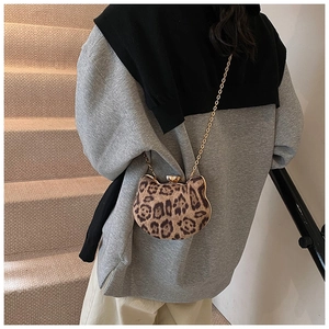 Detail of leopard print cat-ear chain bag worn by model on stairs, stylish velvet texture