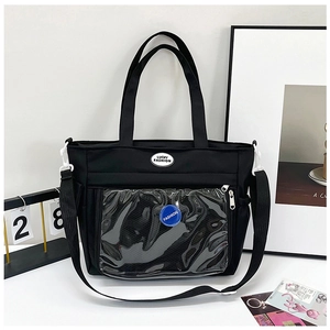 Dettaglio della borsa ita in nylon nero con tasca frontale in PVC trasparente e distintivo