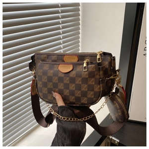 Detail view of brown checkerboard three-in-one crossbody bag with gold chain strap