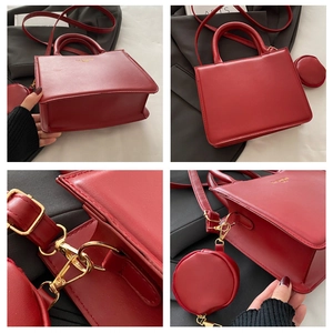 Detail of red leather satchel with round coin purse and adjustable shoulder strap attachment