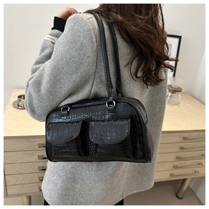 Detail shot of black crocodile embossed faux leather bag with silver zippers and pockets