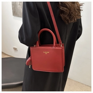 Red crossbody bag with mini coin purse shown on a black coat for a high-contrast look