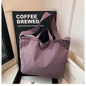 Dettaglio della borsa tote in nylon rosa antico con trama stropicciata e doppi manici