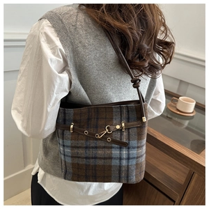 Sac seau en laine à carreaux britanniques avec bandoulière en cuir sur un mannequin