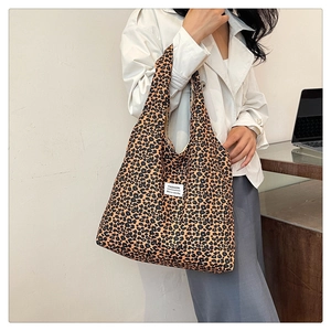 Detail view of large leopard print canvas tote bag showing fashion tag and fabric texture
