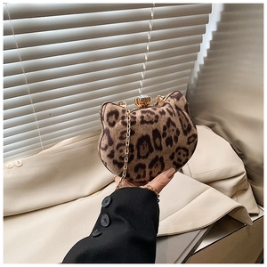 Detailed close-up of a leopard print cat-shaped bag with a golden sunflower clasp