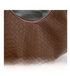 Close-up of the brown woven leather texture and metal zipper detail on the hobo bag